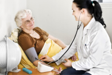 Nurse checking the blood pressure of an elderly